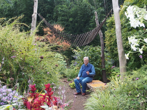 Old man holding checkers by checkerboard bench in Blithewold garden